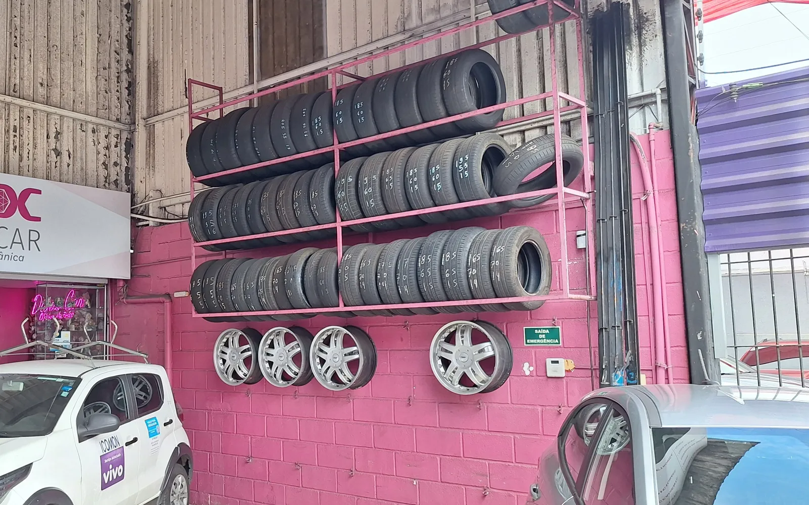 Parede rosa da Divas Car com pneus e rodas, ao lado da recepção